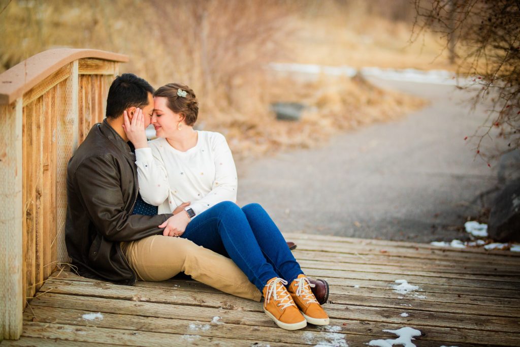 Jackson Hole wedding photographer captures couple cuddle at pond in pocatello idaho on bridge