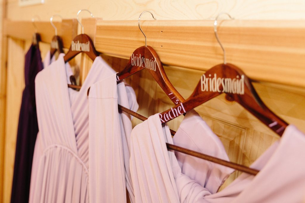 Jackson Hole wedding photographer captures Bridesmaid dressing hanging up before wedding in the color purple and lilac