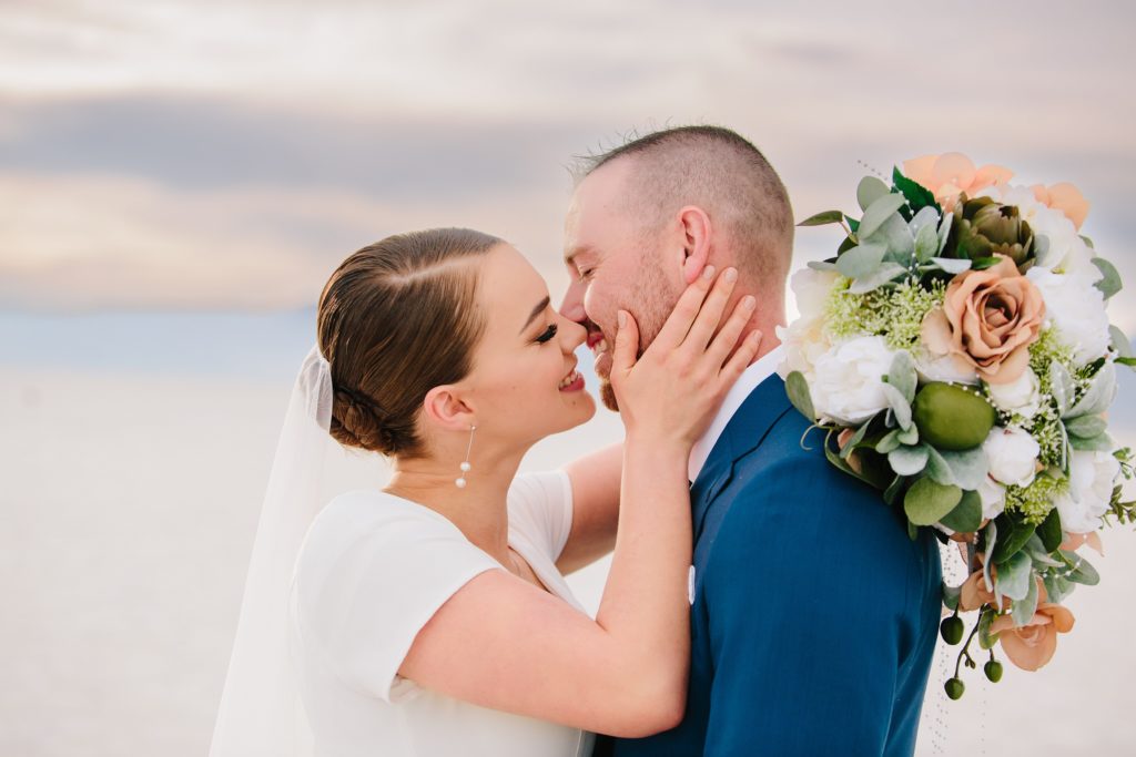 Jackson Hole wedding photographer captures Smile kiss bride and groom at salt flats utah happy photography