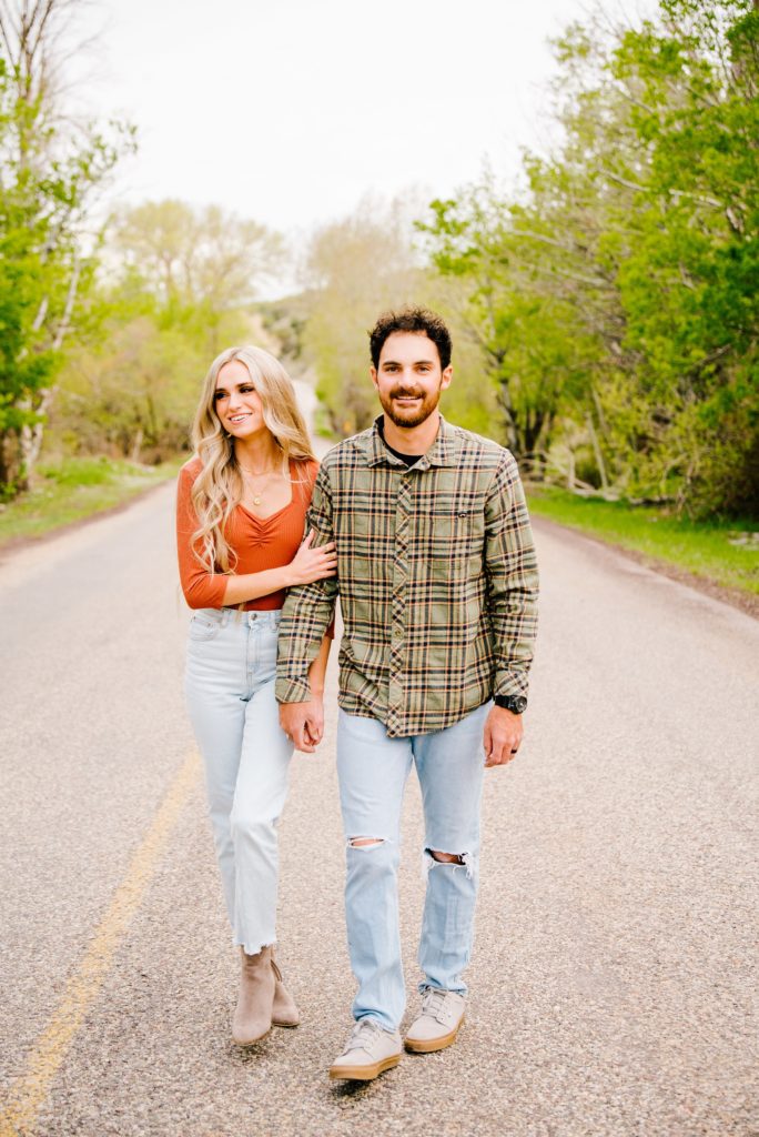 Jackson Hole wedding photographer captures Couple walking down the road while holding hands 
