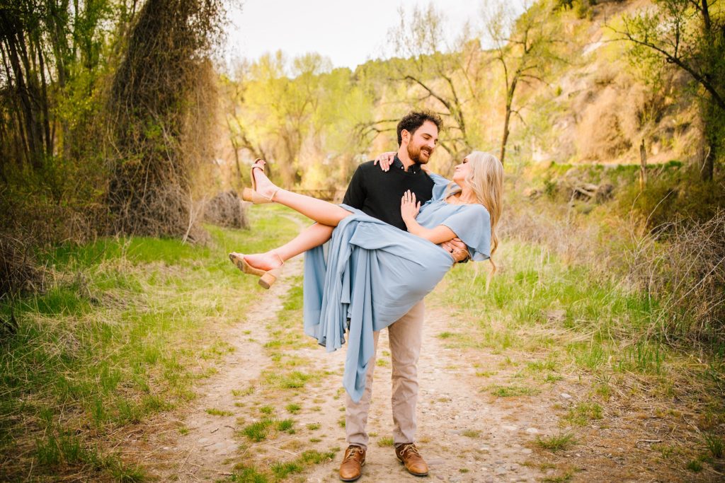 Jackson Hole wedding photographer captures Man holding woman in blue dress in mountains