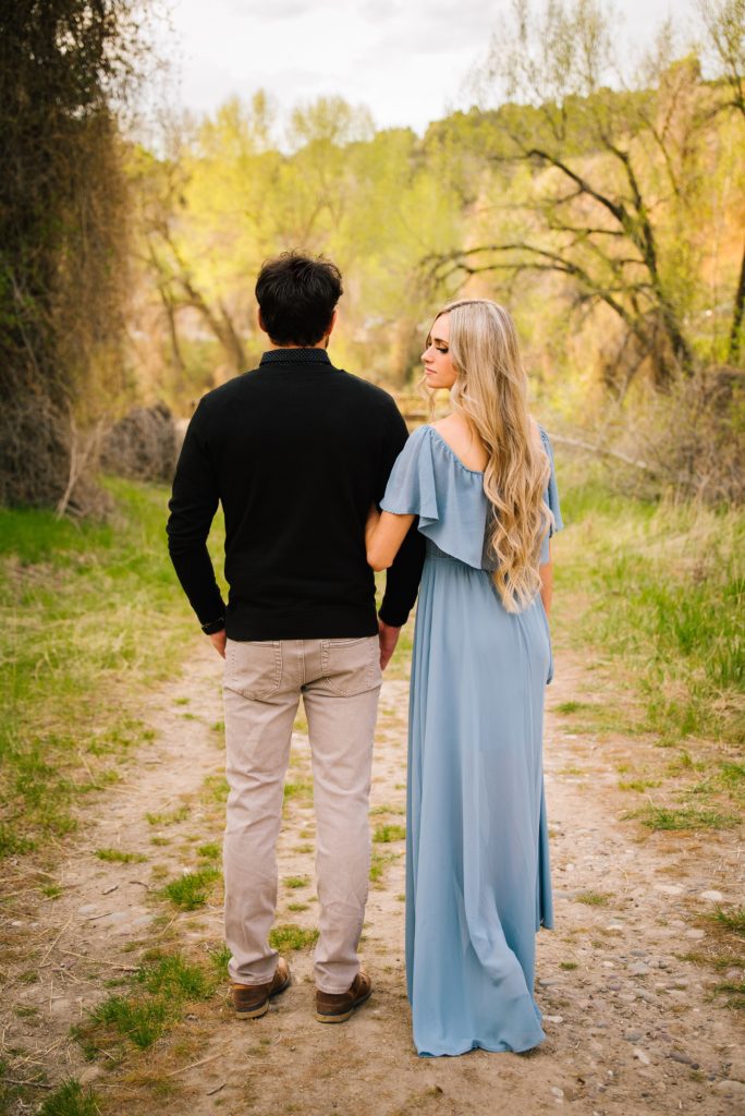Jackson Hole wedding photographer captures Couple turned away from camera girl wearing blue dress