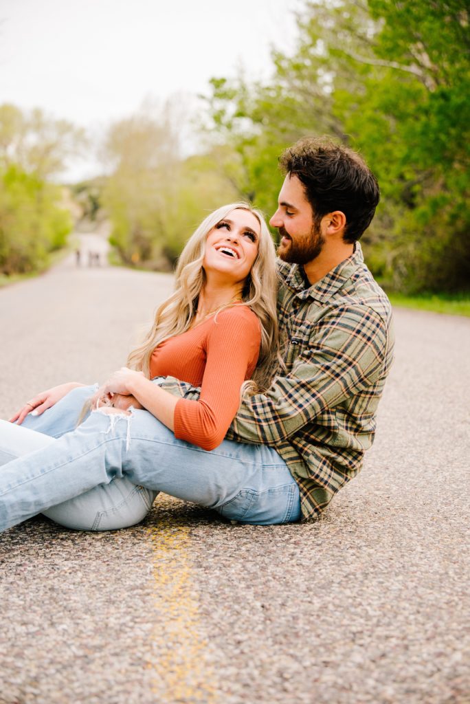 Jackson Hole wedding photographer captures sitting in road couple in mountains