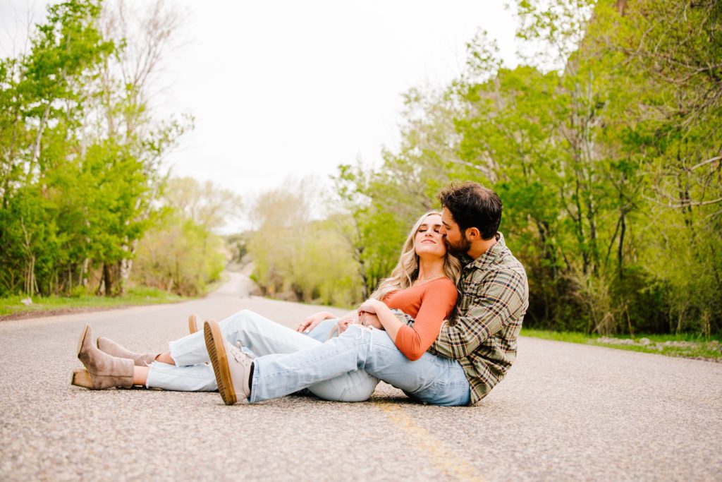 Jackson Hole wedding photographer captures couple lays in road for kiss