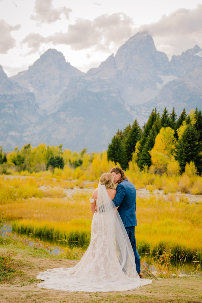Jackson Hole wedding photographer captures bride and groom looking at the Tetons