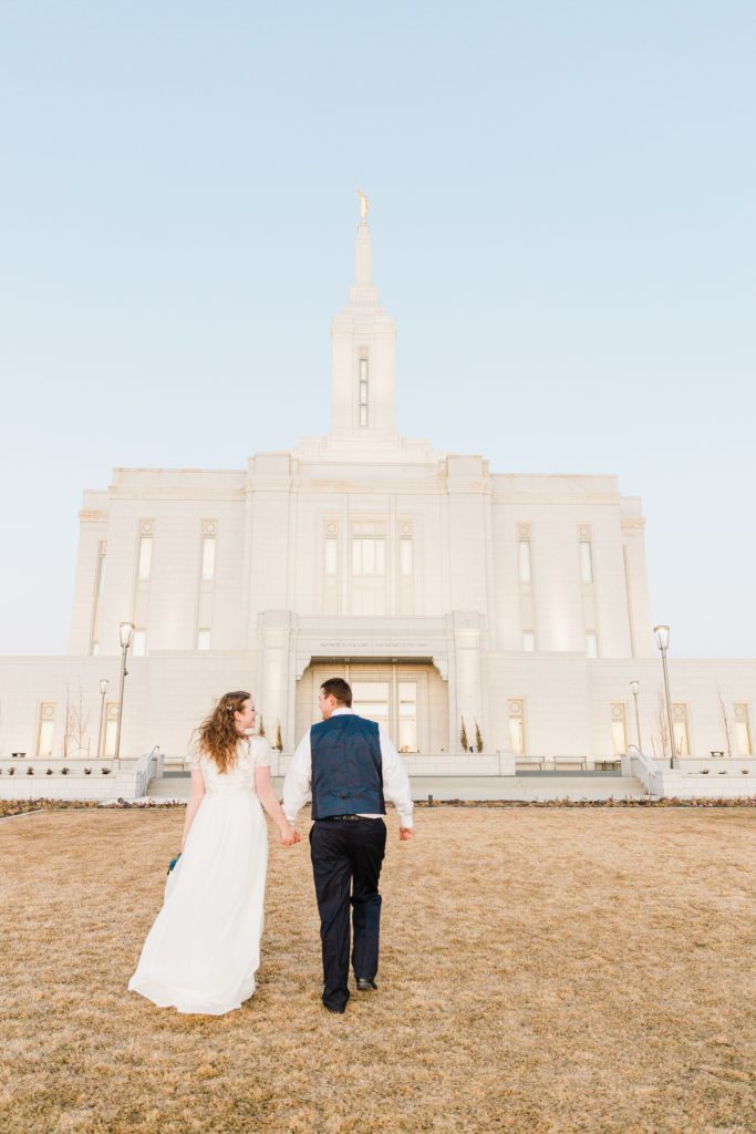 Jackson Hole wedding photographer captures bride and groom walk to temple Chilly Pocatello Temple Bridals