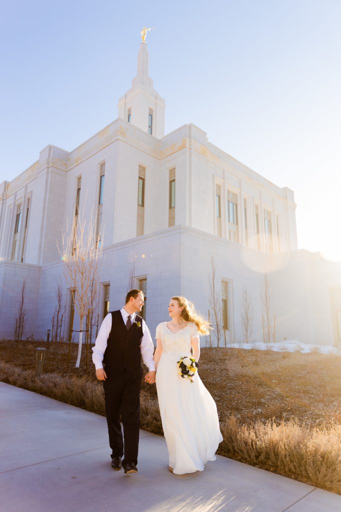 Jackson Hole wedding photographer capturesChilly Pocatello Temple Bridals at corner of temple bride and groom