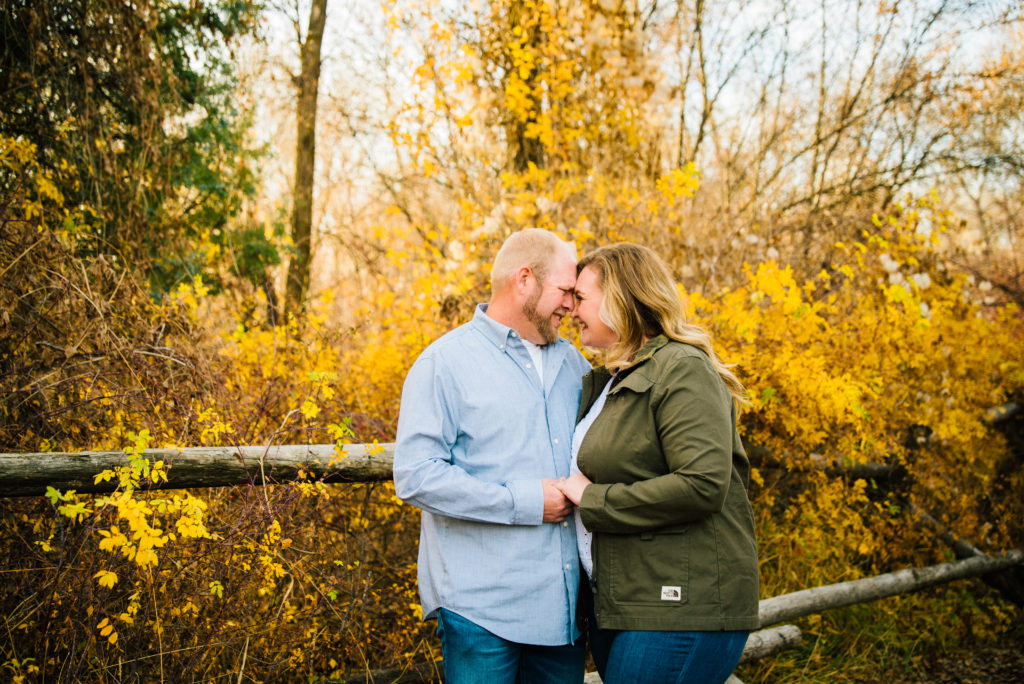 Jackson Hole wedding photographer captures couple gives butterfly kisses as they embrace each other during fall engagement session