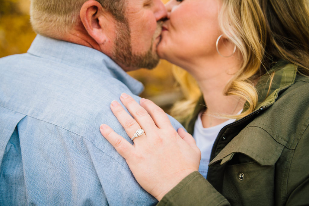 Jackson Hole wedding photographer captures Her hand on his back showing off her wedding ring during fall engagement session