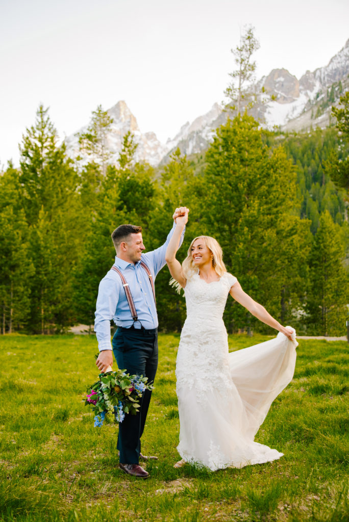 Jackson Hole wedding photographer captures groom spinning bride after getting married in Grand Teton National Park
