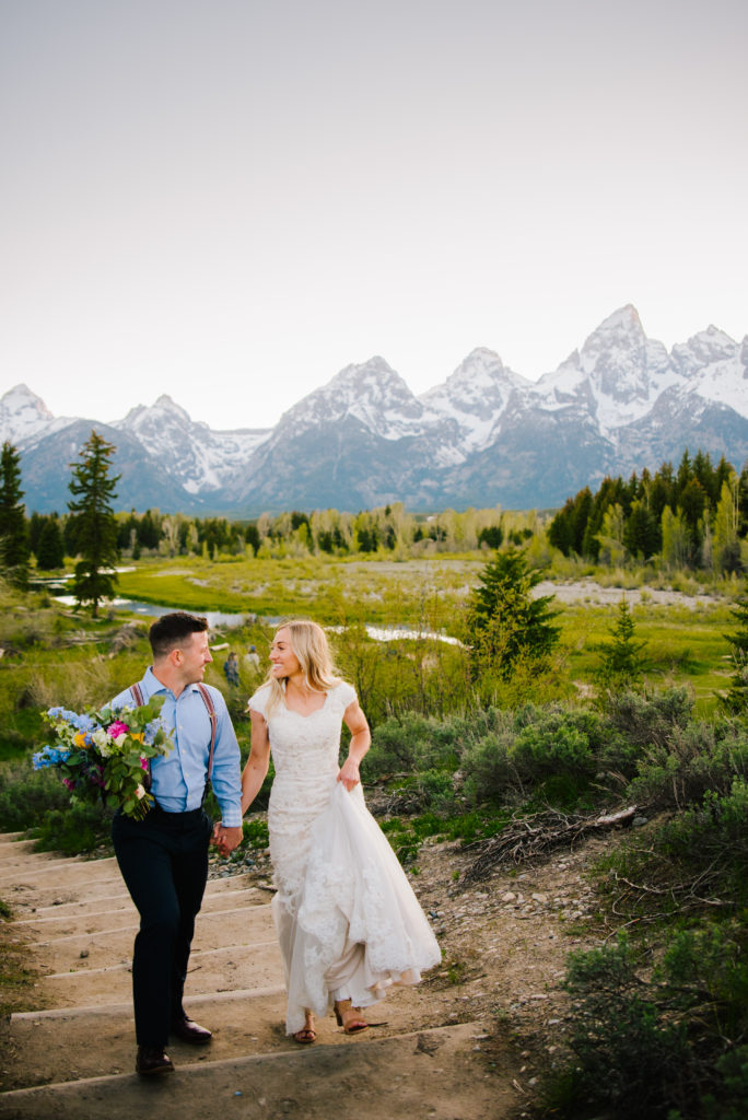Jackson Hole wedding photographer captures bride and groom walking through Grand Teton National Park