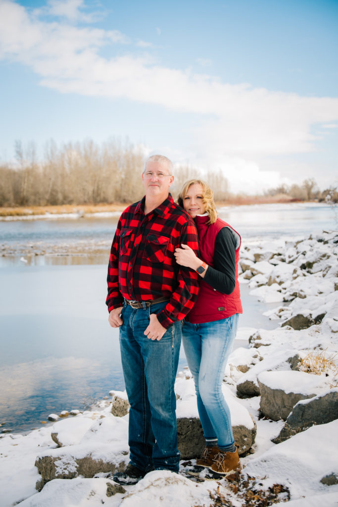 Jackson Hole wedding photographer captures Couple sanding by frozen river in rigby idaho