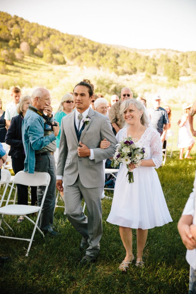 Jackson Hole wedding photographer captures bride walking down on her wedding day with son