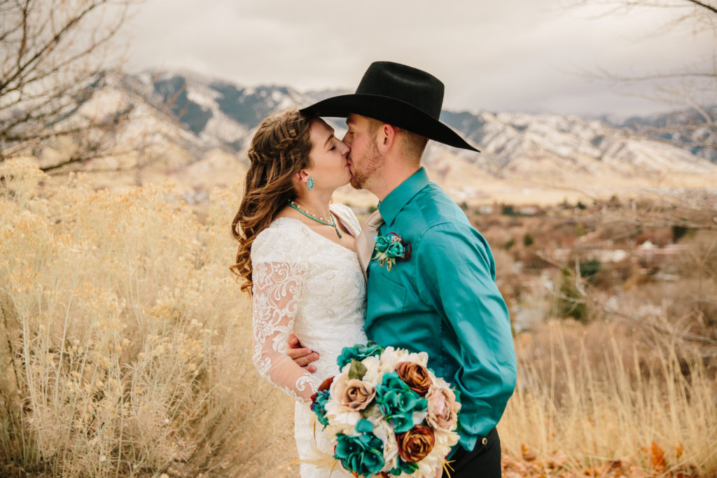 groom leans into his bride as he kisses her for their fall wedding