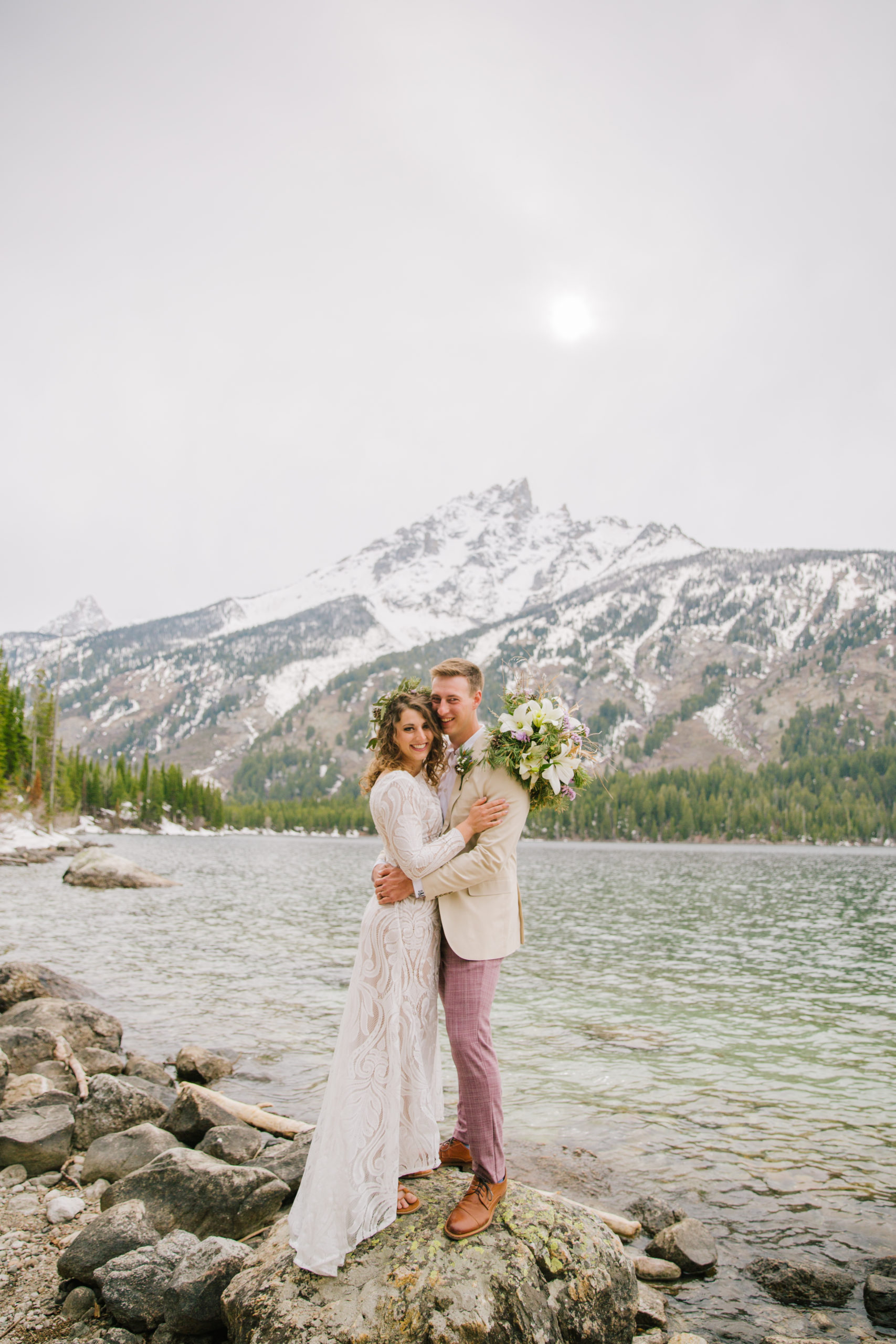bride and groom hugging on water front during bridals in national park