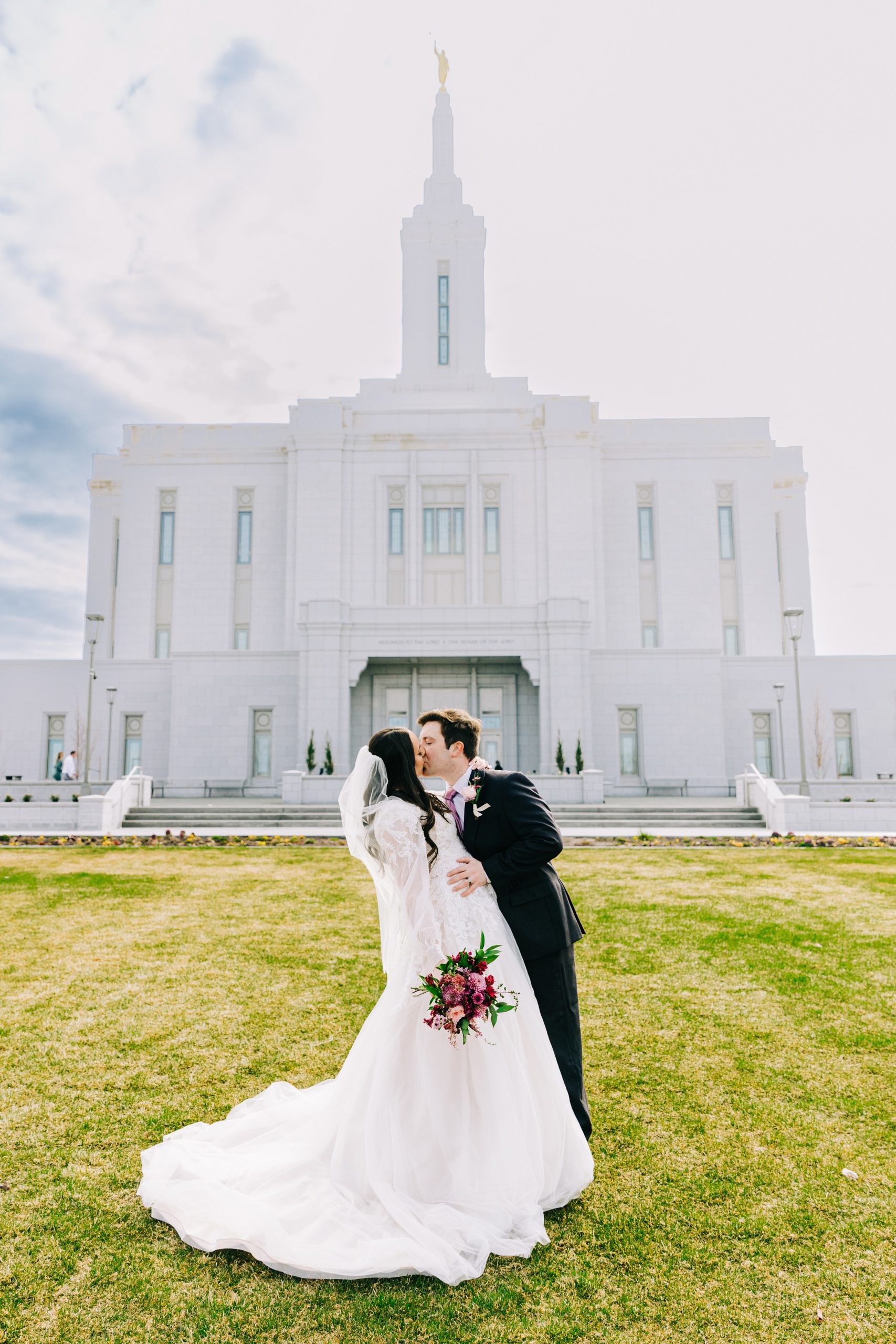 groom dip and kisses bride on the lds temple grounds during bright pocatello temple bridals
