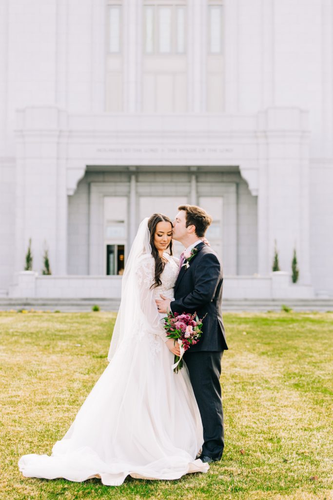 bride and groom embrace each other during the bright pocatello temple bridals pocatello wedding photogrpaher