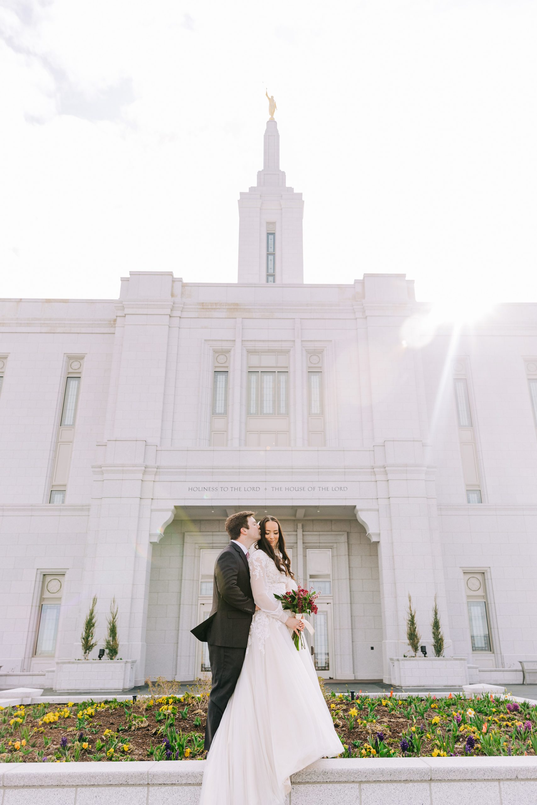 windy bright pocatello bridals with couple standing on garden bed with temple behind them