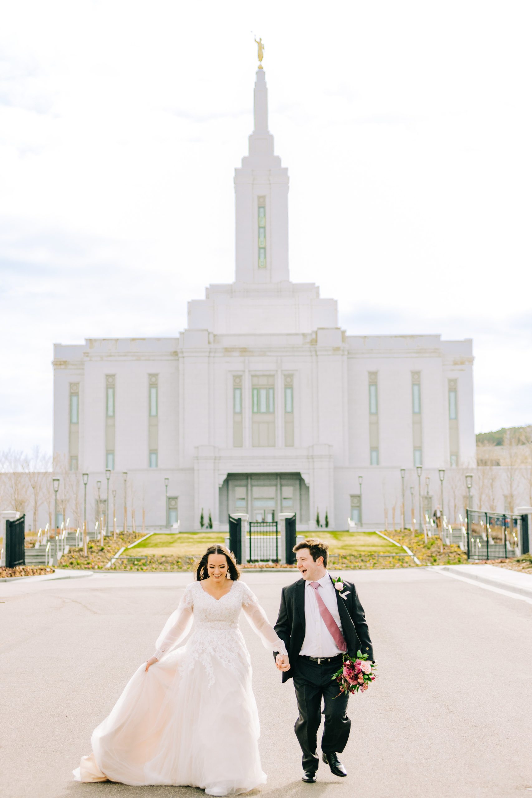 bride and groom on street with pocatello temple in view