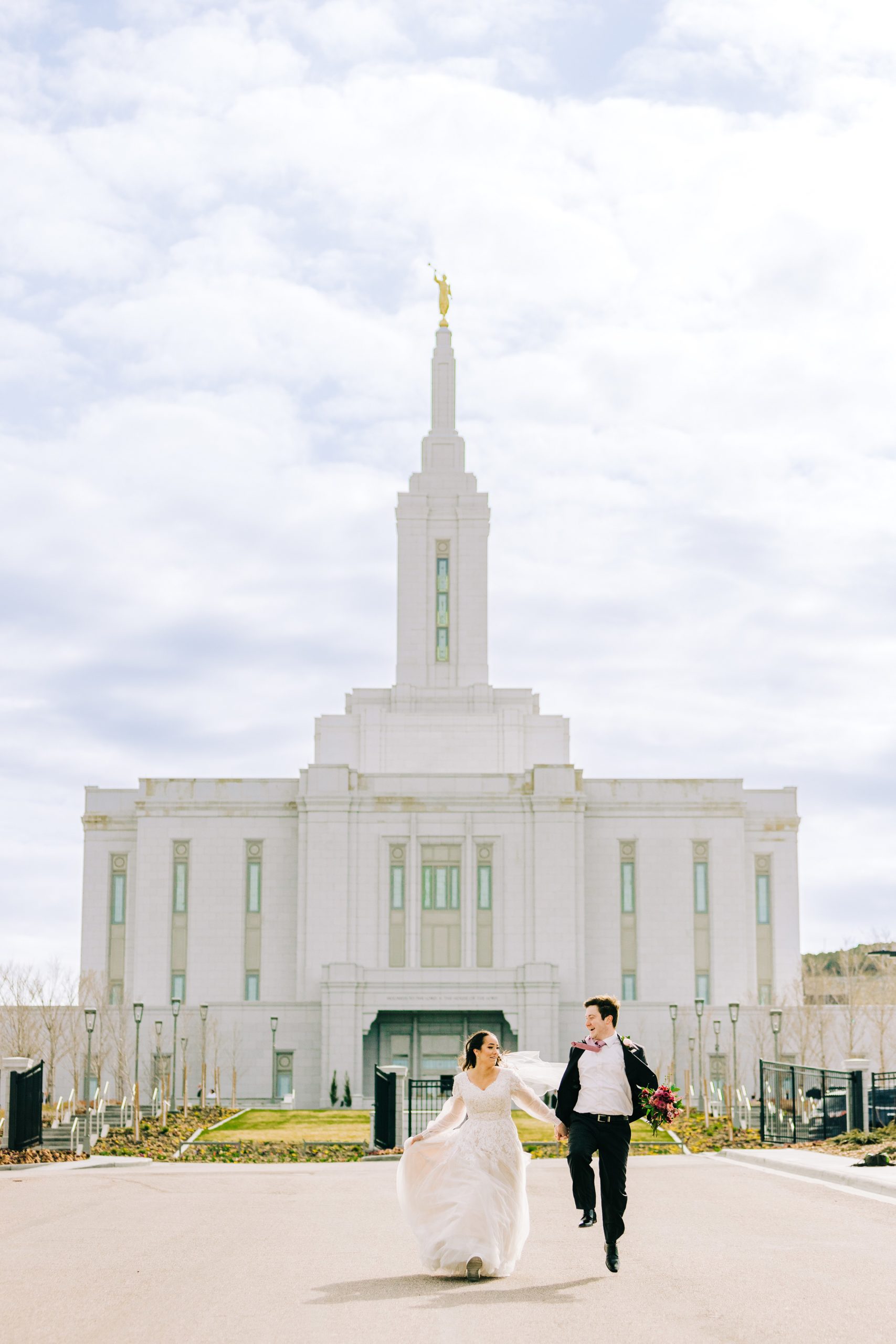 skipping down the road from the pocatello temple the bride and groom hold hands