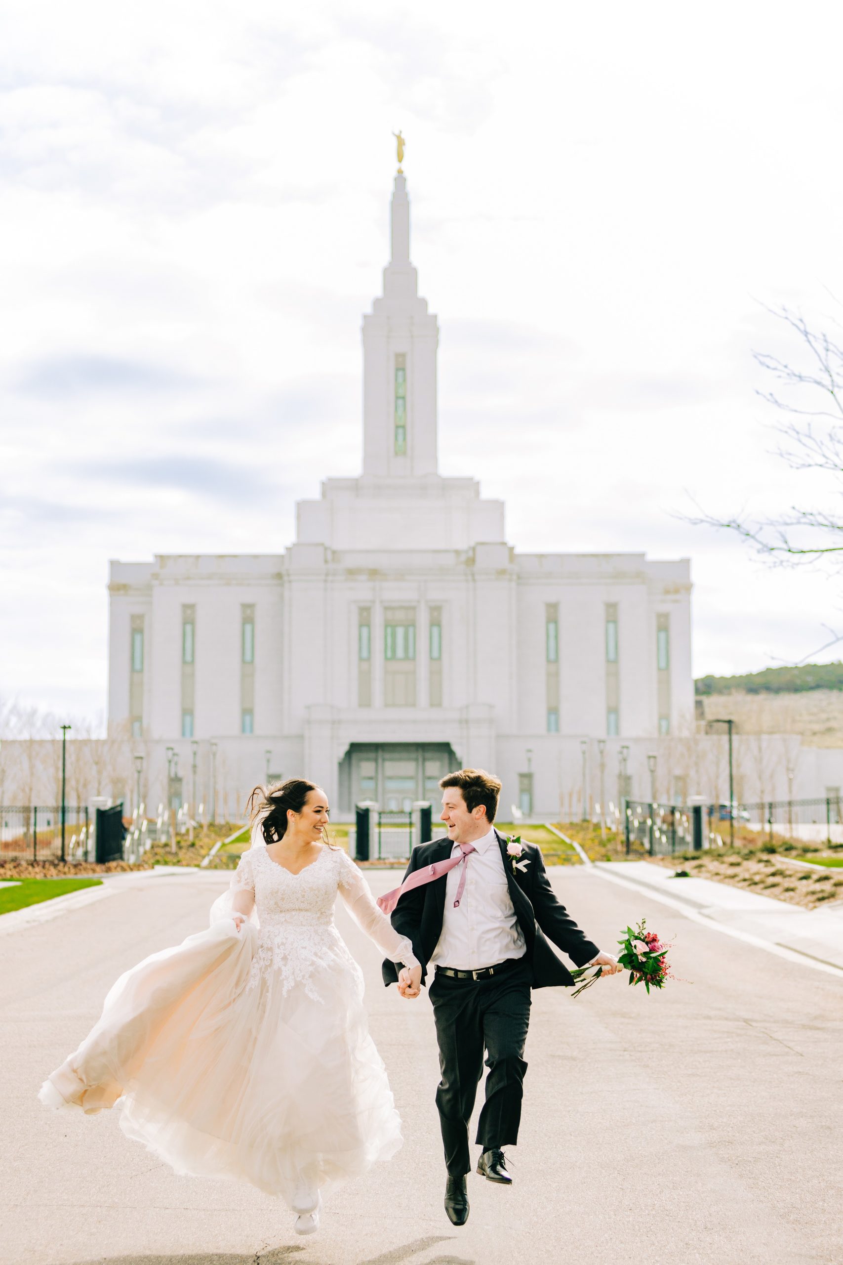 skipping bride and groom on windy day at pocatello temple wedding