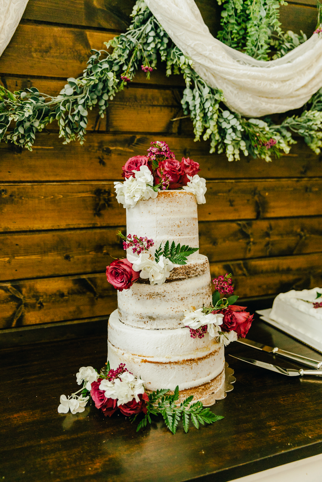three tier wedding cake from Pocatello wedding bakery with white frosting and pink florals 