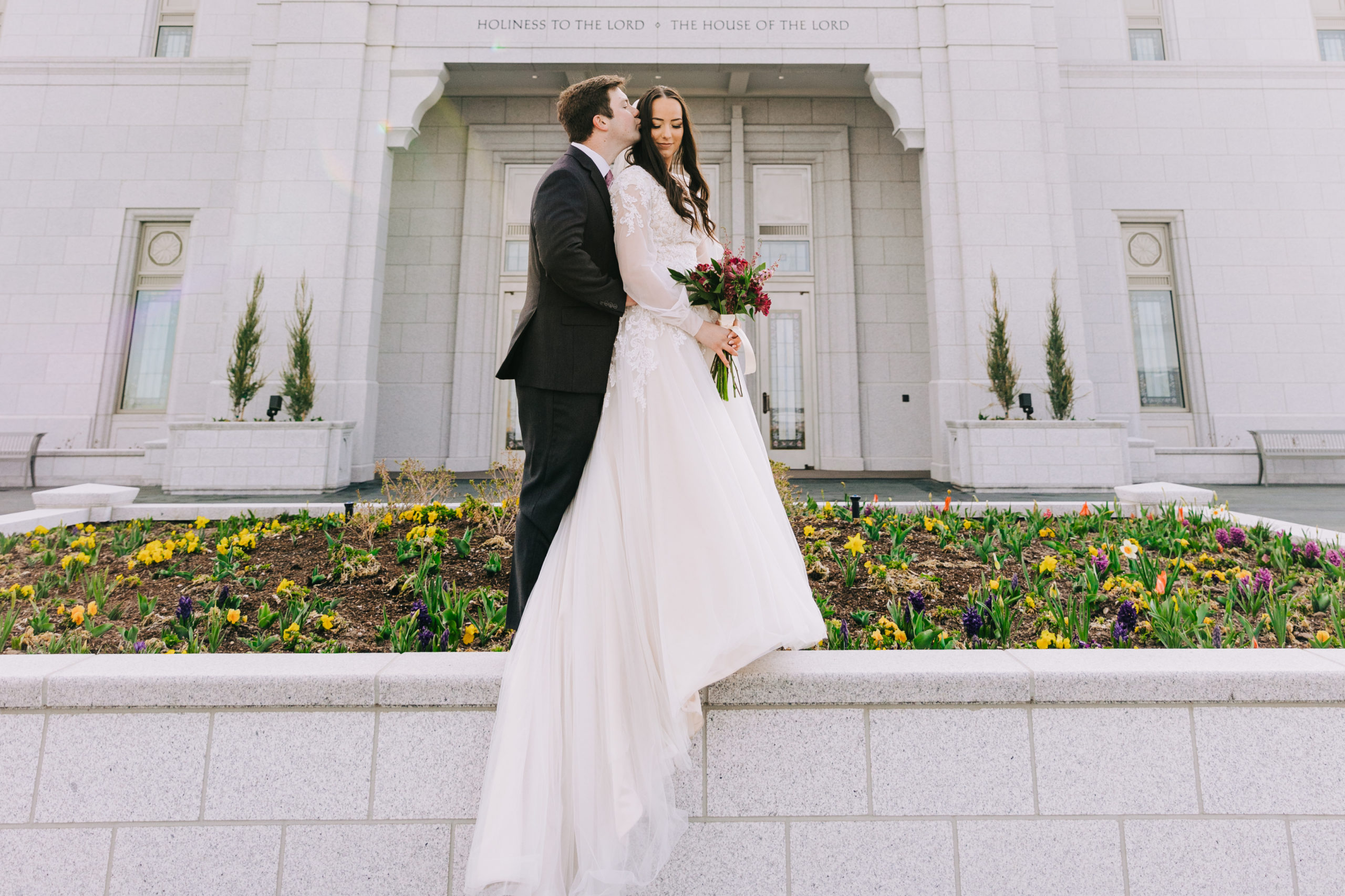 bride and groom standing on wall at Pocatello temple during bridals portraits