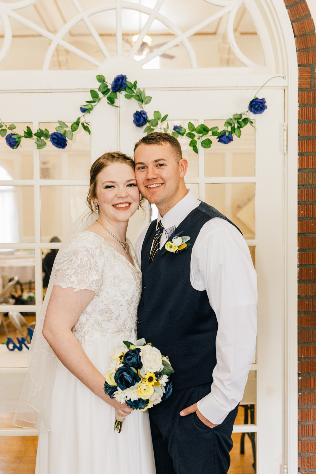 Jackson Hole wedding photographer captures bride and groom standing by window doors