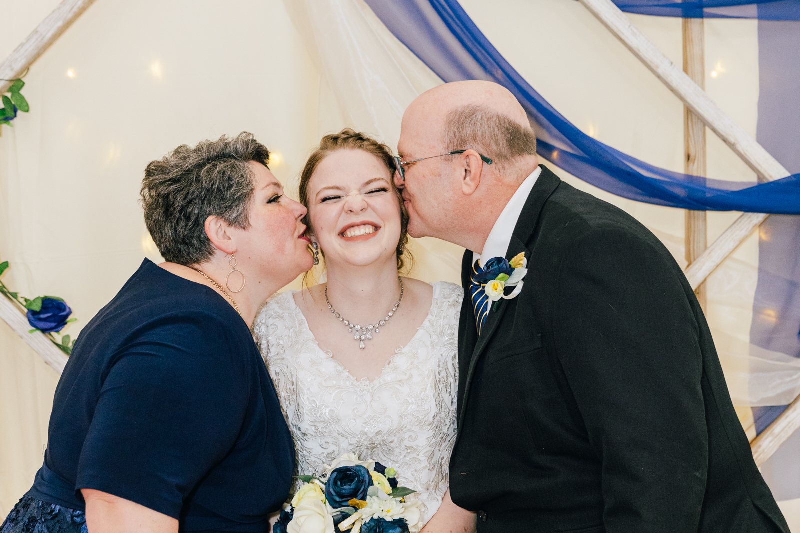 Jackson Hole wedding photographer captures bride being kissed by parents pocatello temple