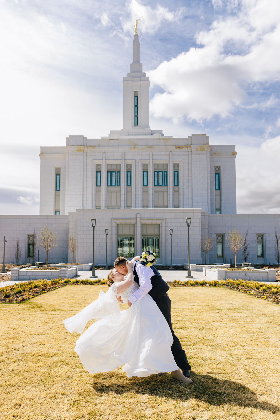Jackson Hole wedding photographer captures bride and groom kissing in front of temple