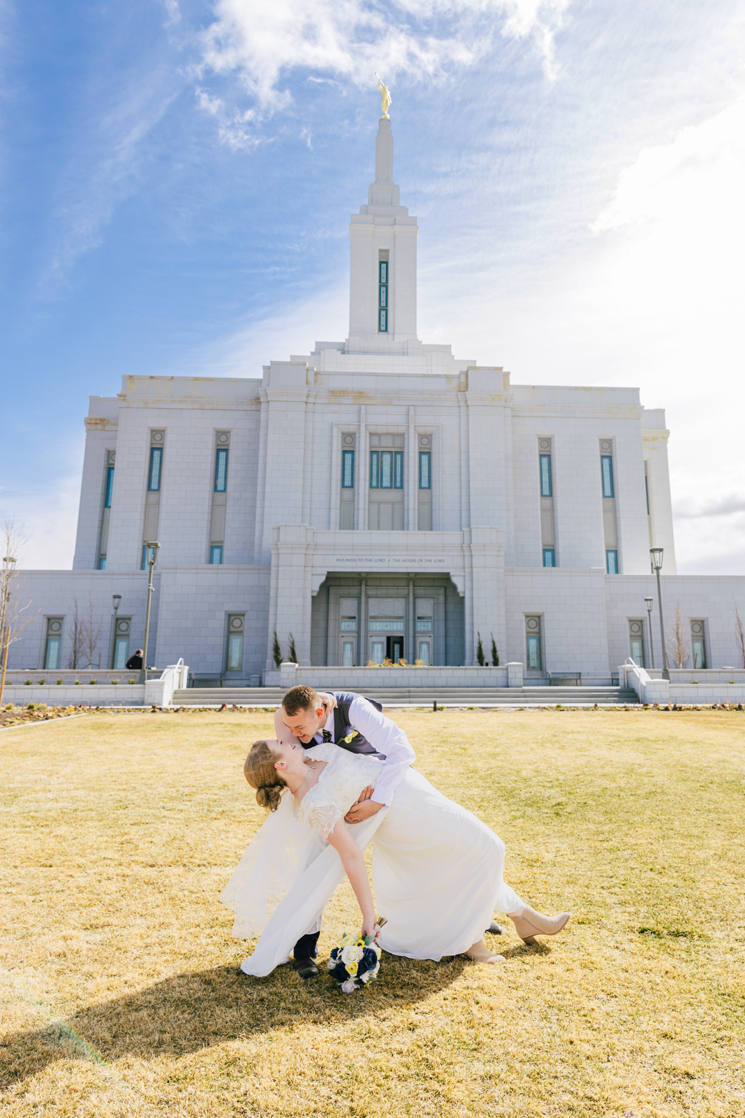 Groom dips and kisses bride in pocatello temple wedding photogrpahy