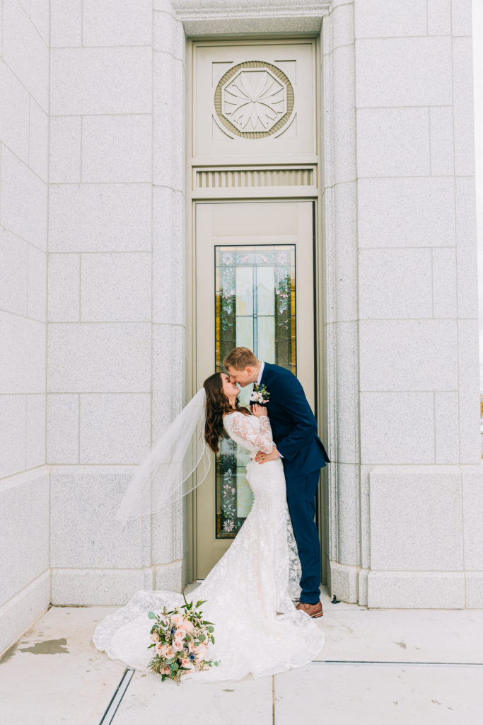 Jackson Hole wedding photographer captures couple kisses outside of pocatello temple door