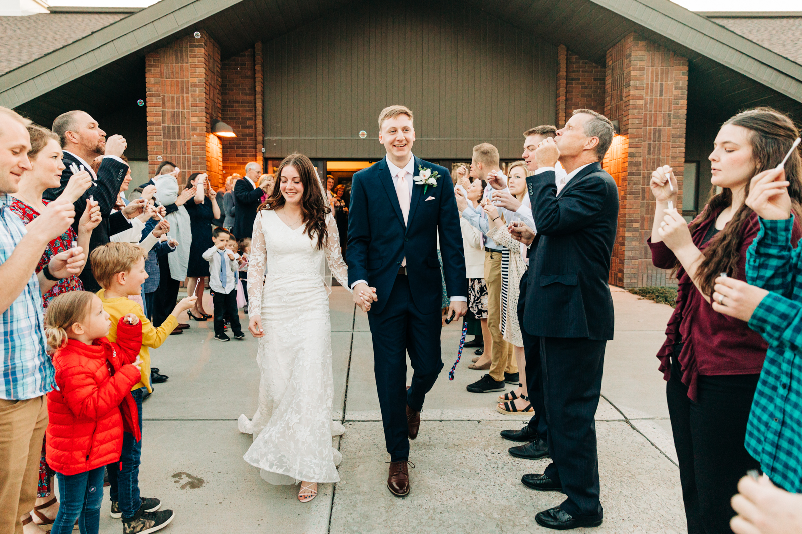 Jackson Hole wedding photographer captures bride and groom leaving snowy wedding reception hand in hand