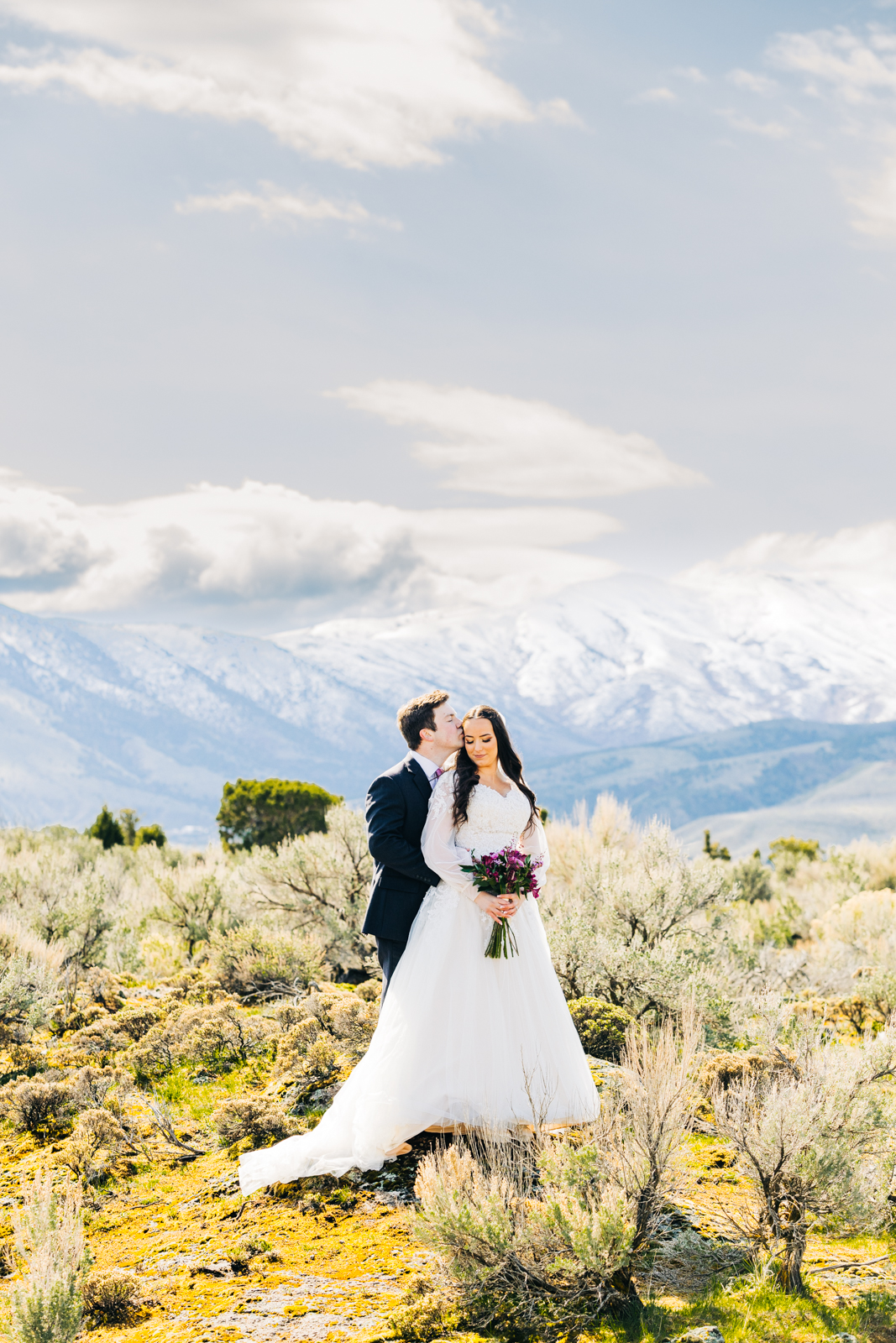 Jackson Hole wedding photographer captures bride and groom embracing in a field in the Tetons 
