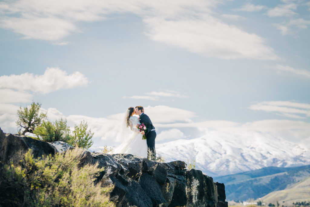 couple kissing on top of pocatello mountain after wedding