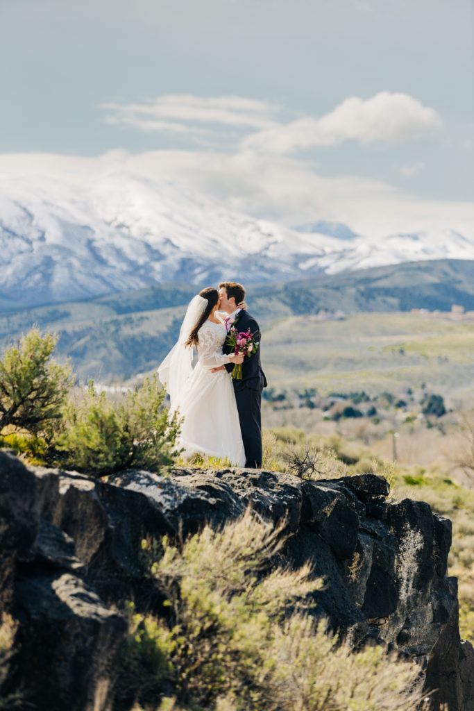 Jackson Hole wedding photographer captures Close up of wedding couple on cliff after pocatello lds wedding kissing