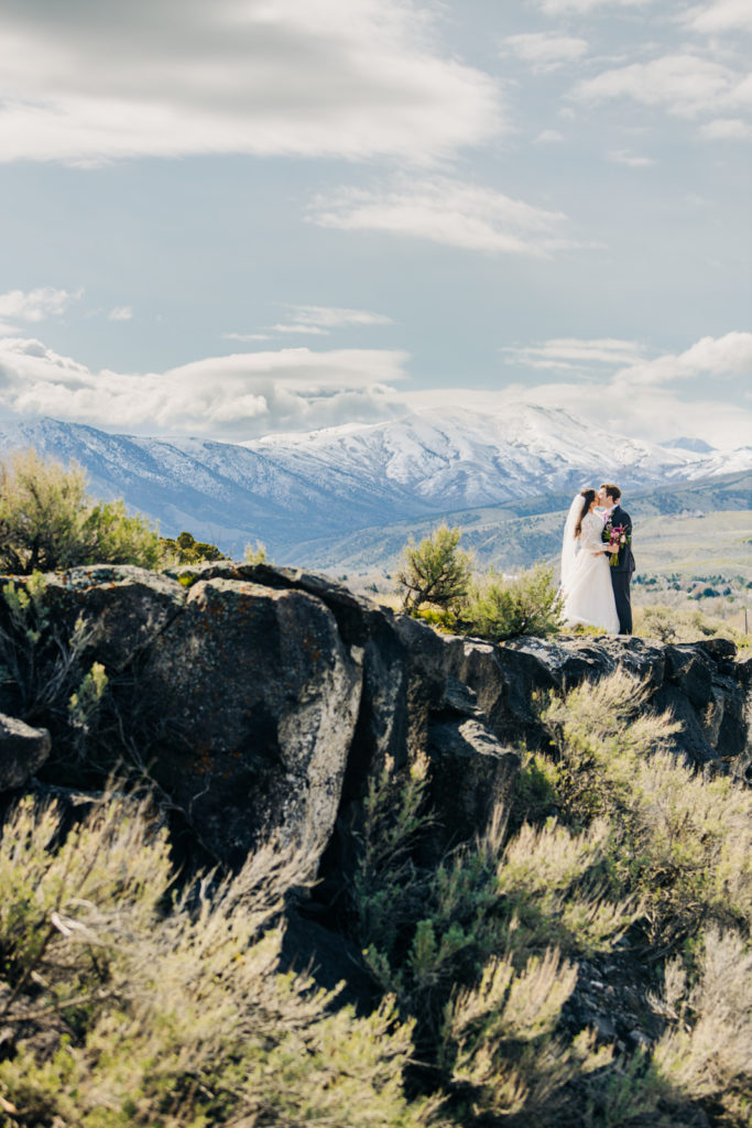 Jackson Hole wedding photographer captures Bride and groom kissing on cliff in pocatello idaho after wedding