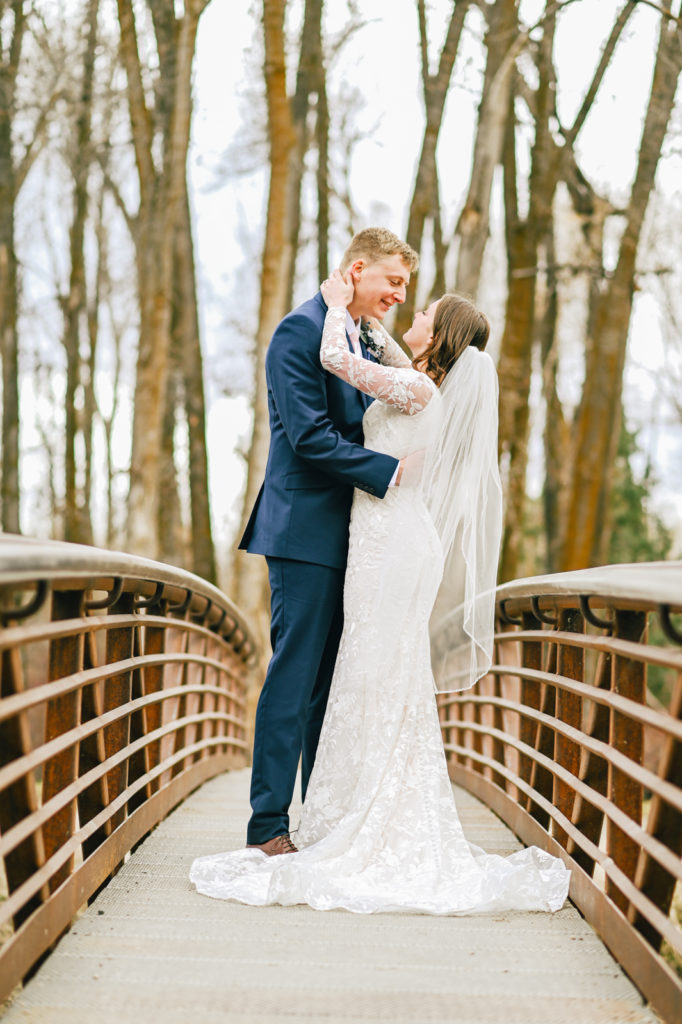 bride and groom embracing on a bridge together for their Pocatello wedding day