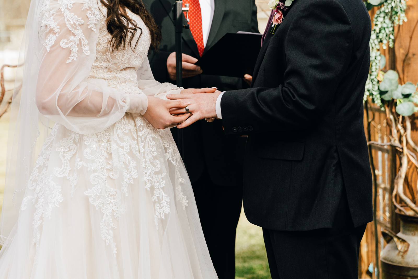 Jackson Hole wedding photographer capturesbride slides grooms ring on