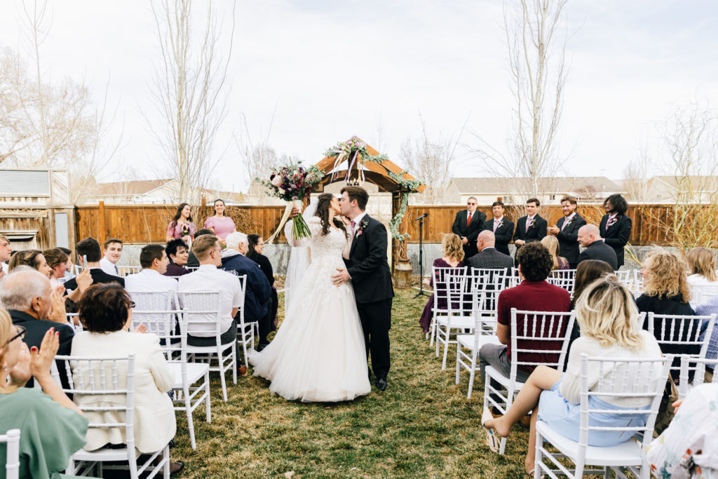 Jackson Hole wedding photographer captures bride and groom kissing at alter as husband and wife