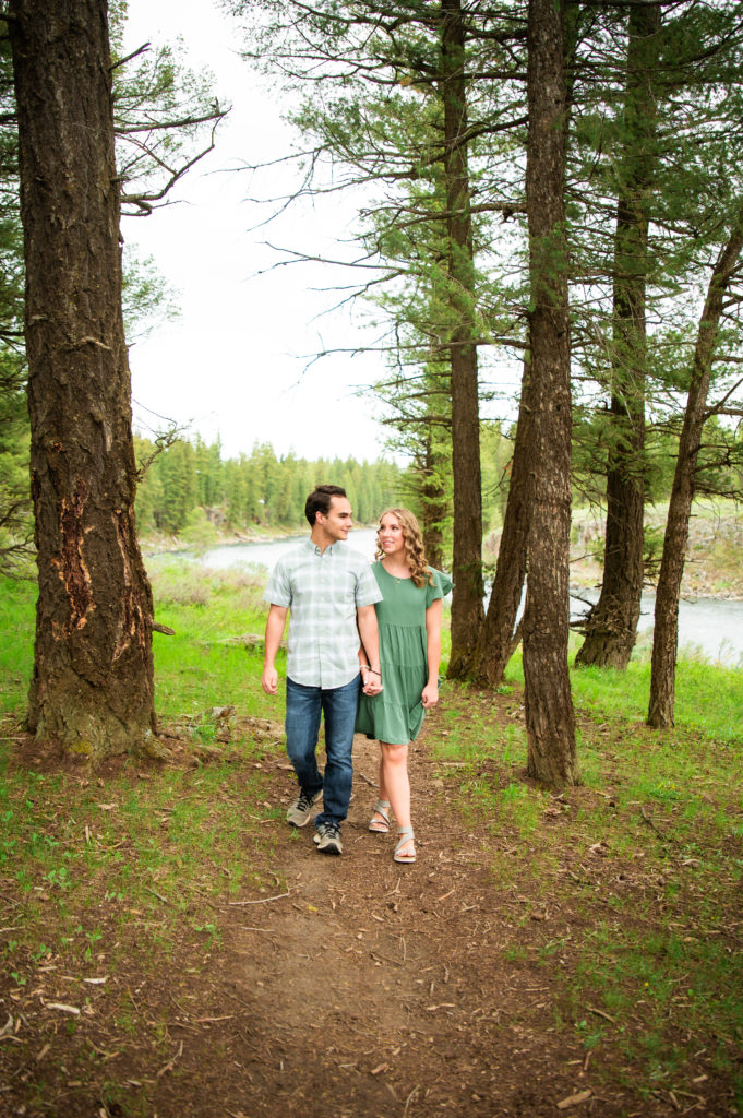 couple walking through forest during outdoor engagement session