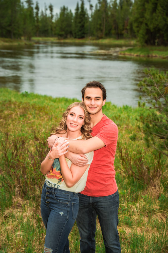 man wrapping arms around woman's shoulders 
