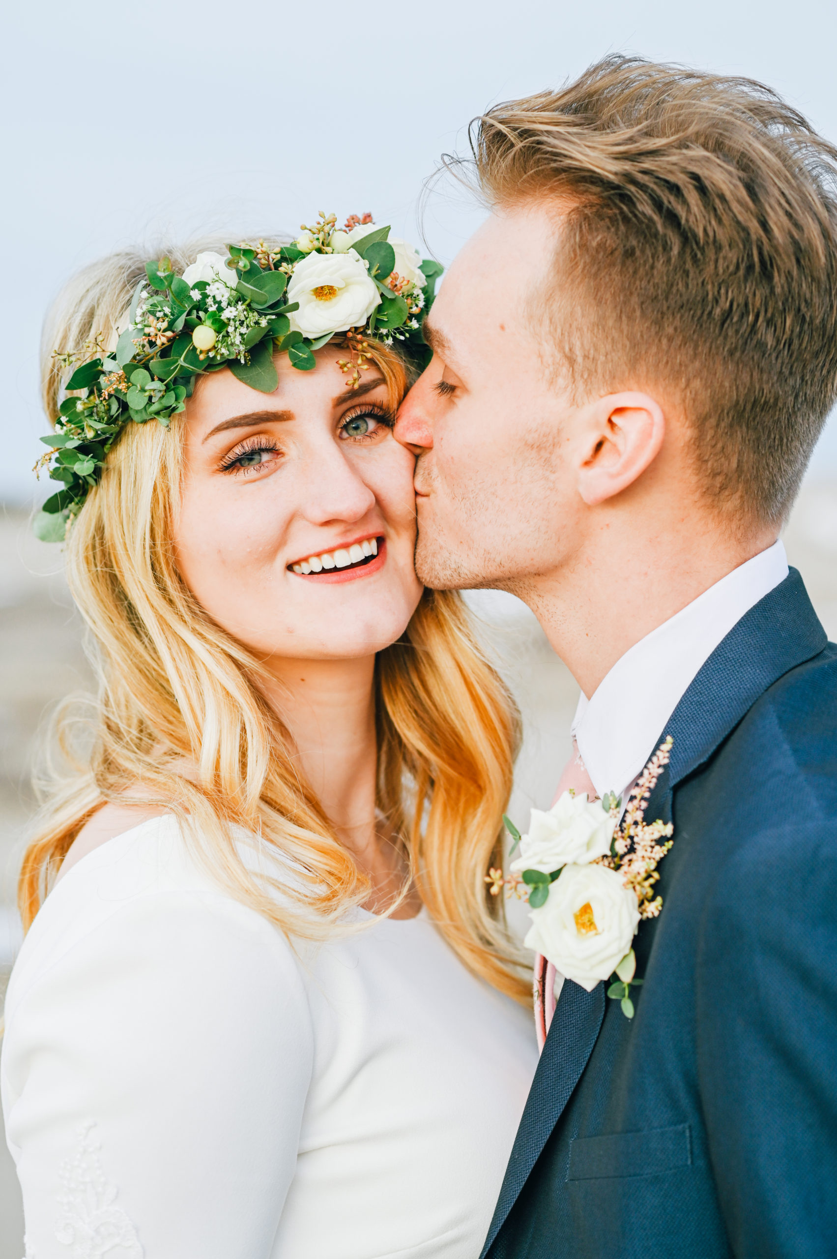 bride laughing as groom kisses cheek 