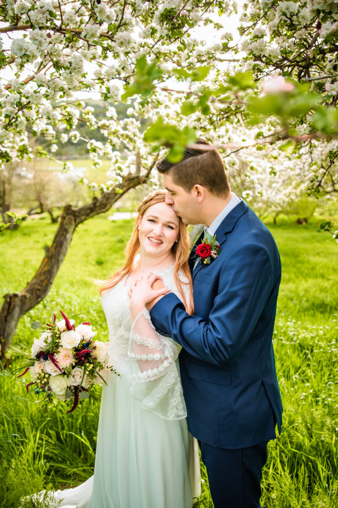 groom kissing bride's head during Blossom Pocatello Bridals