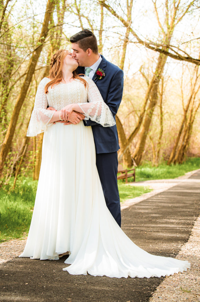 bridal couple kissing during outdoor portraits