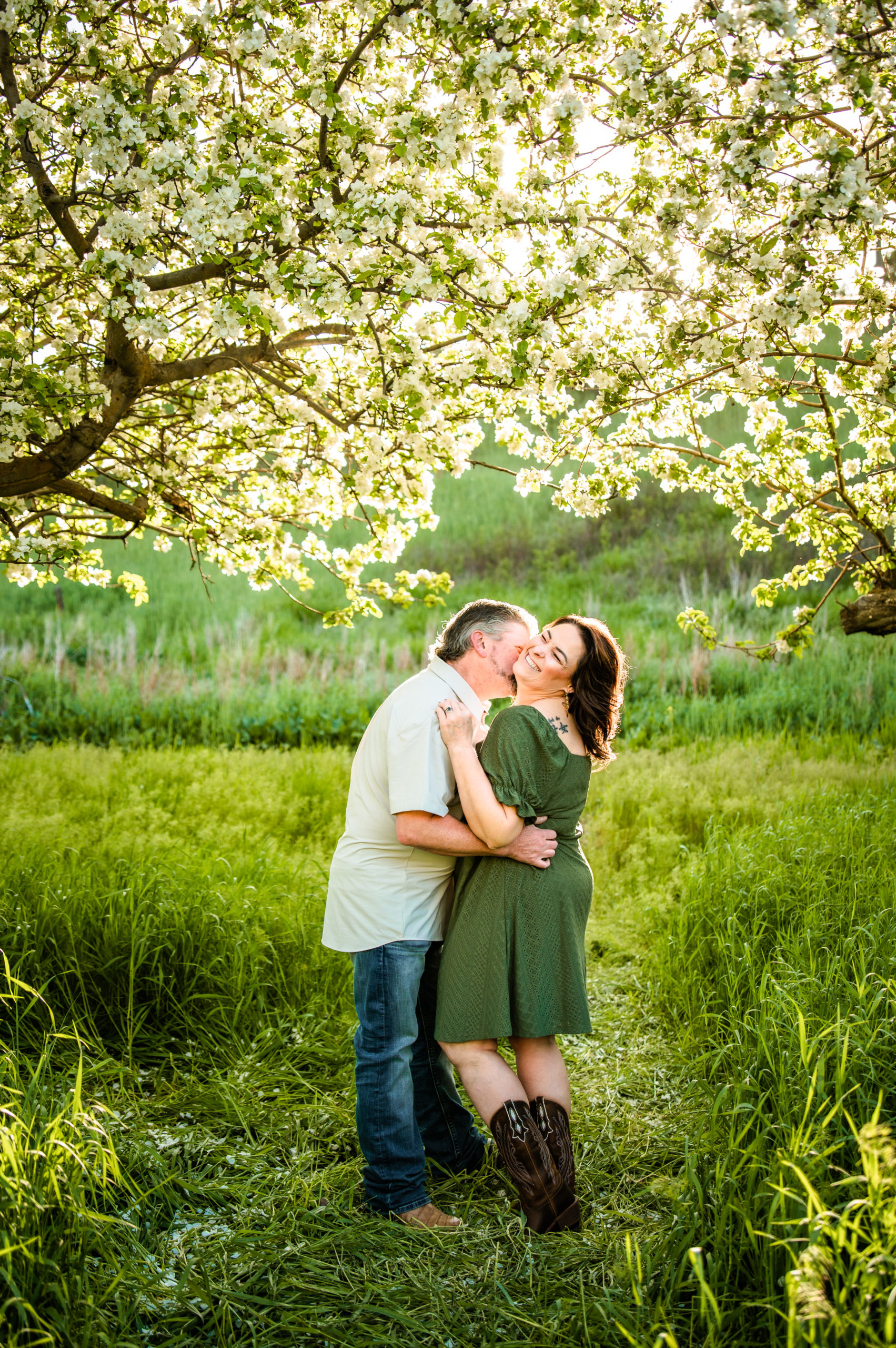 man and woman embracing in field of grass during engagements