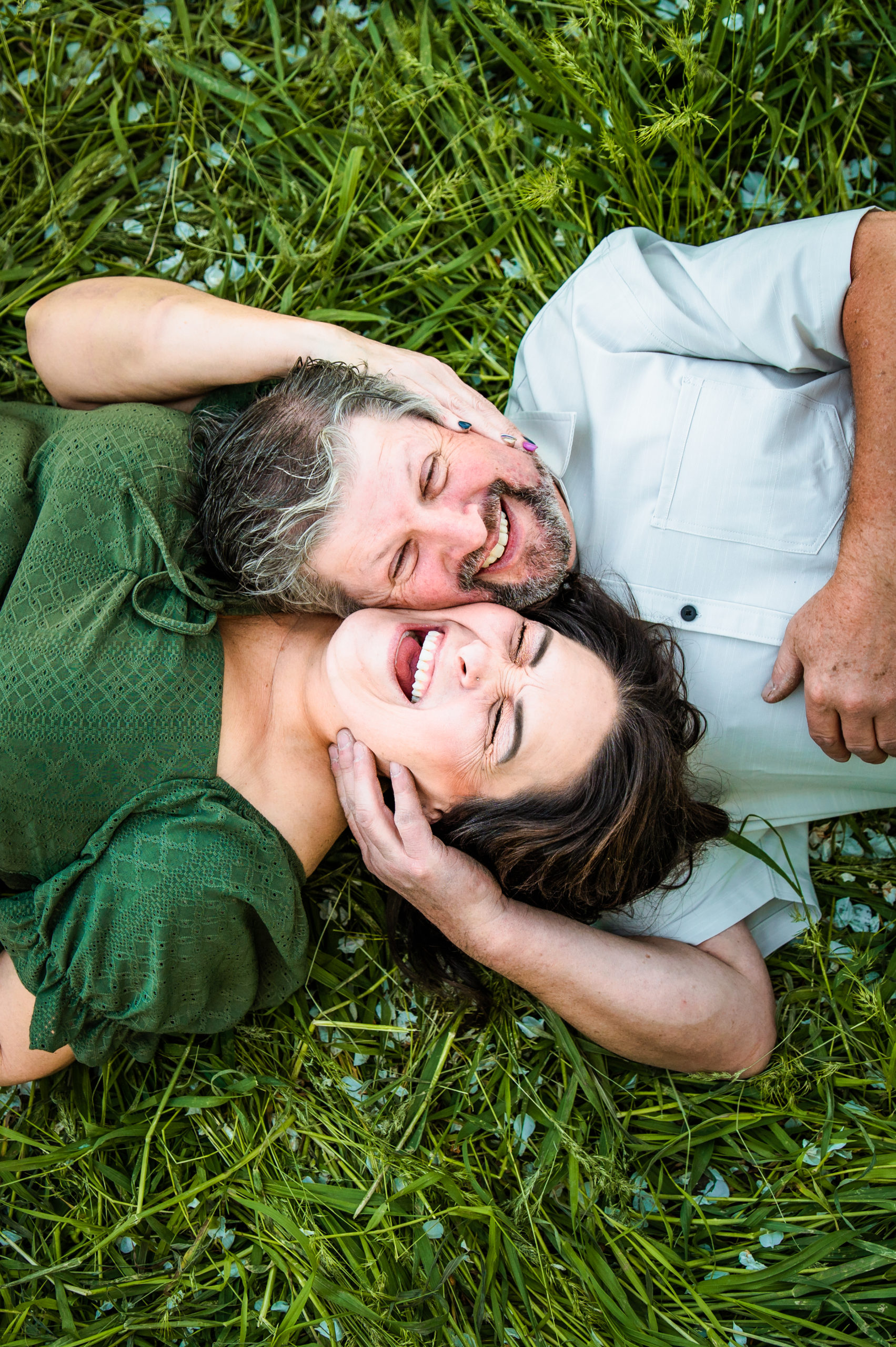 man and woman laughing together in the grass