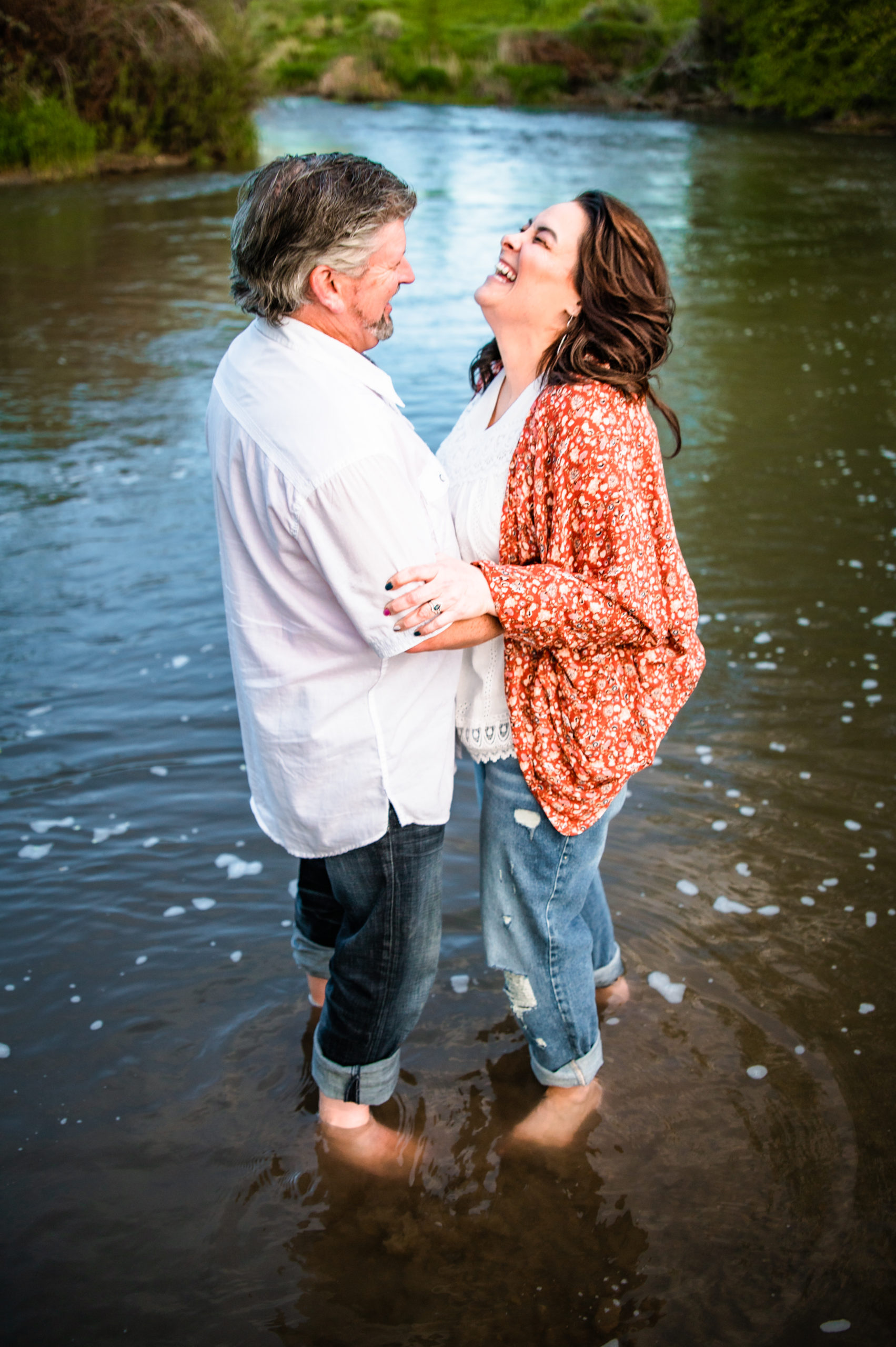 couple laughing together while wading in water