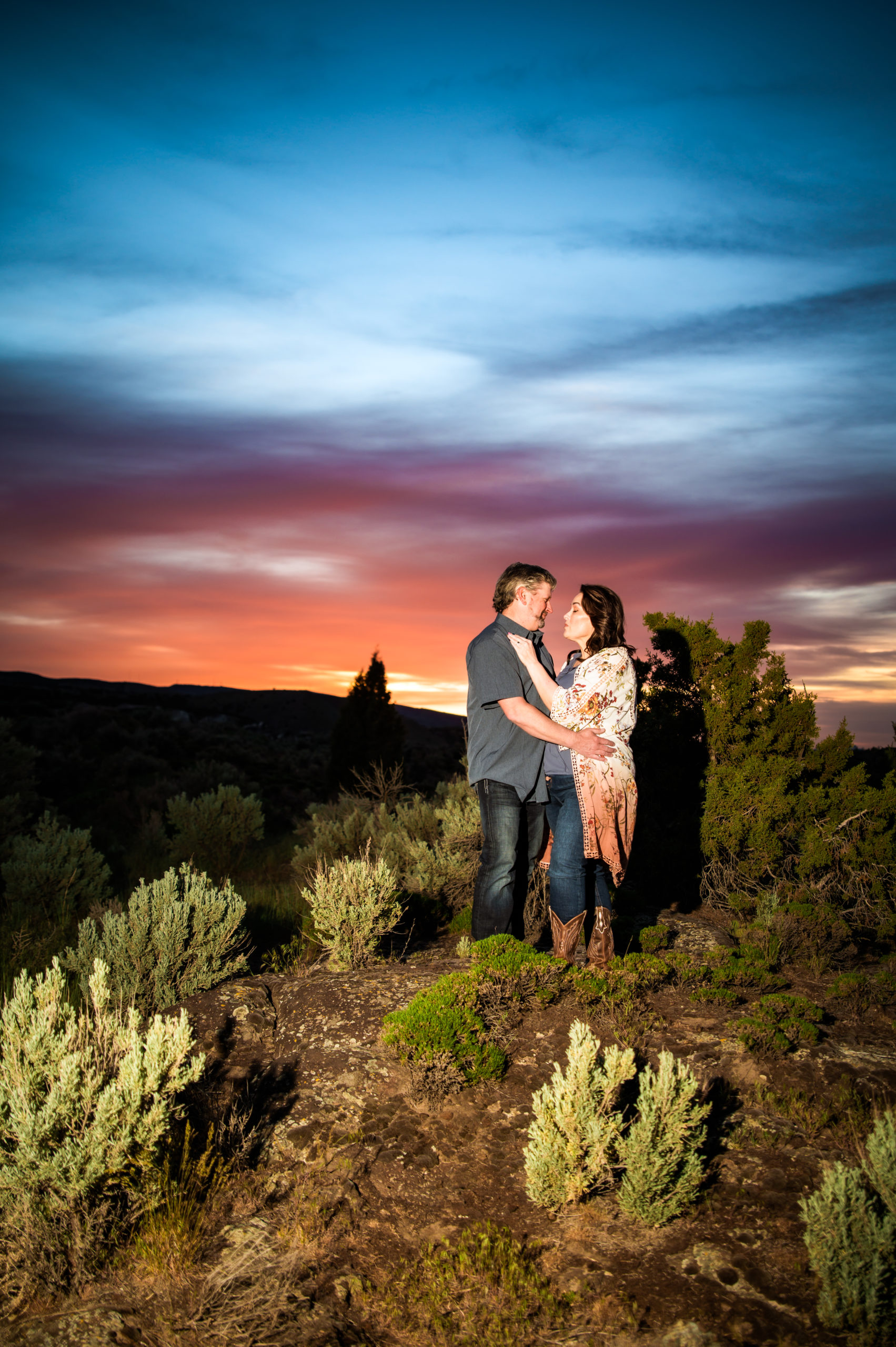 couple standing in field during sunset portraits