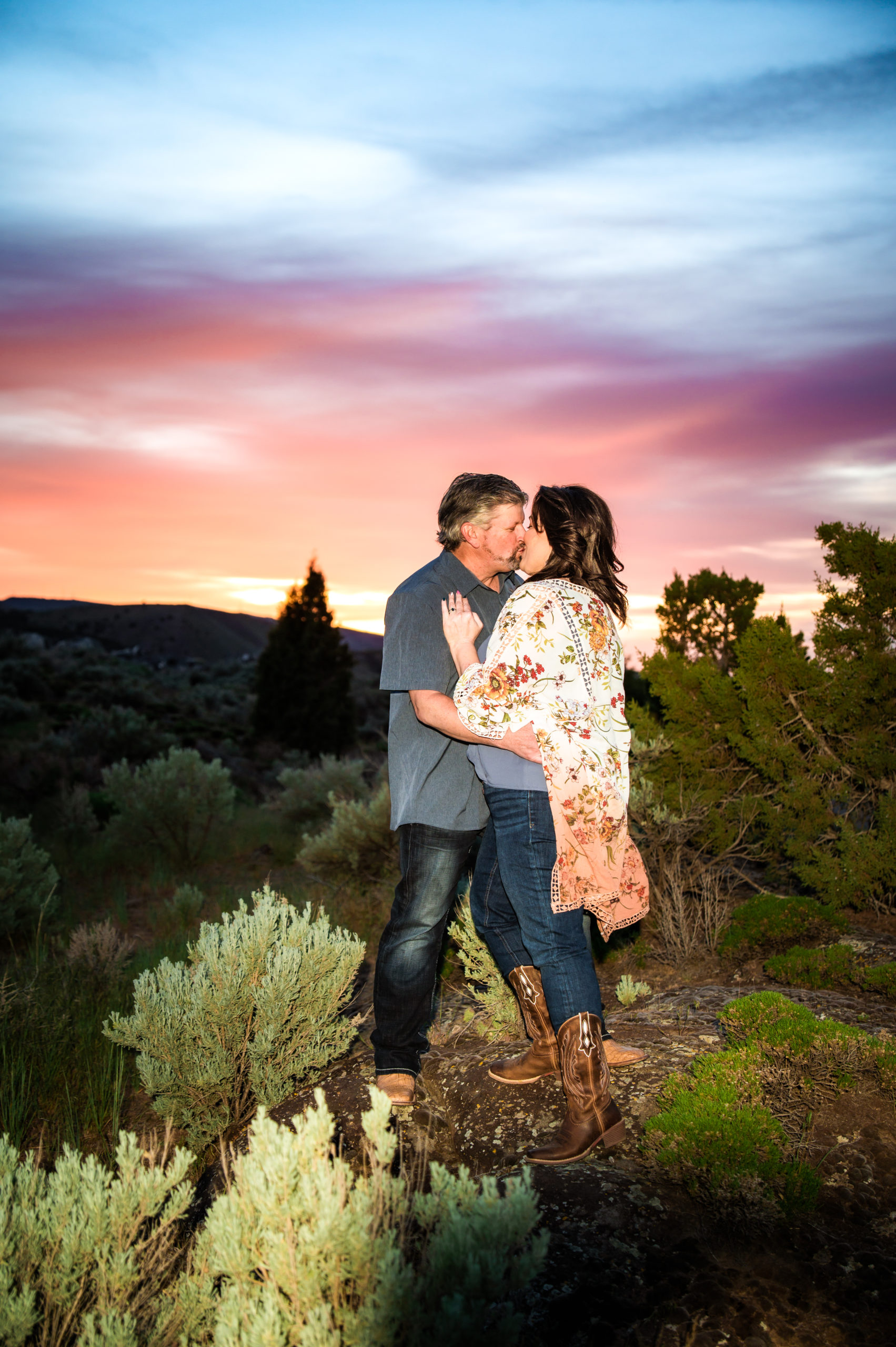 man and woman kissing at sunset engagement portraits